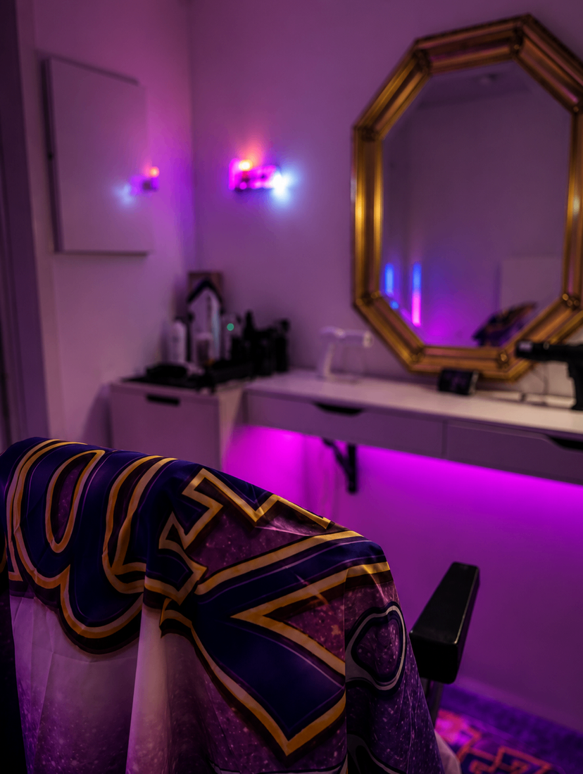 The Fadez studio station with gold mirror, neon sign and pink ambient lighting